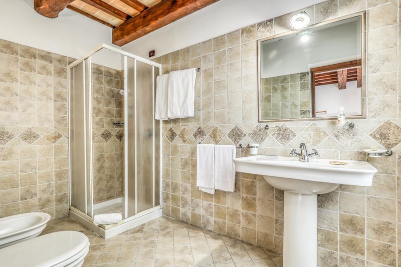 Bagno privato della camera, con doccia e rivestimento in pietra