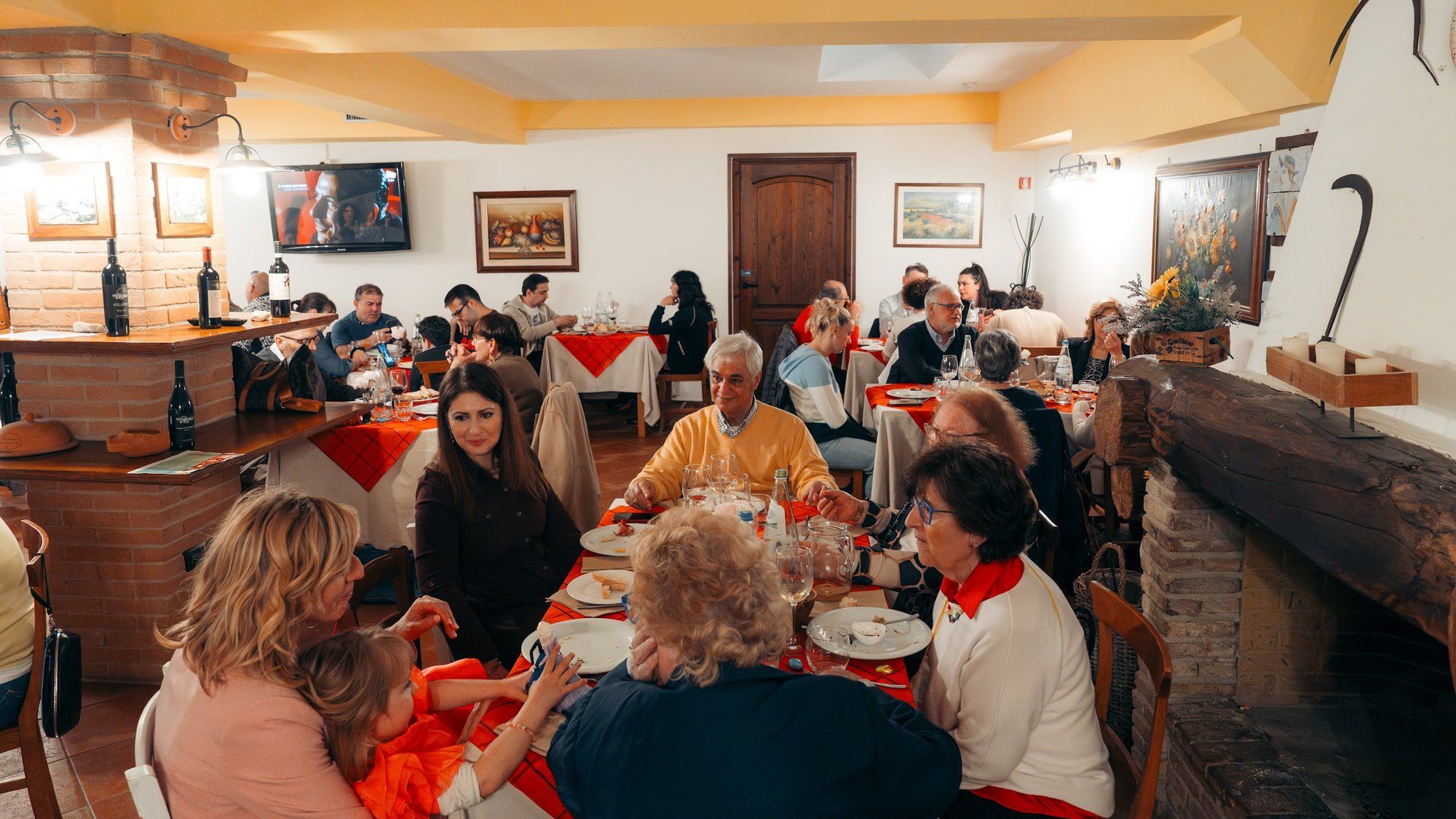 Famiglie a tavola nella sala con il camino, con i nonni e una bambina